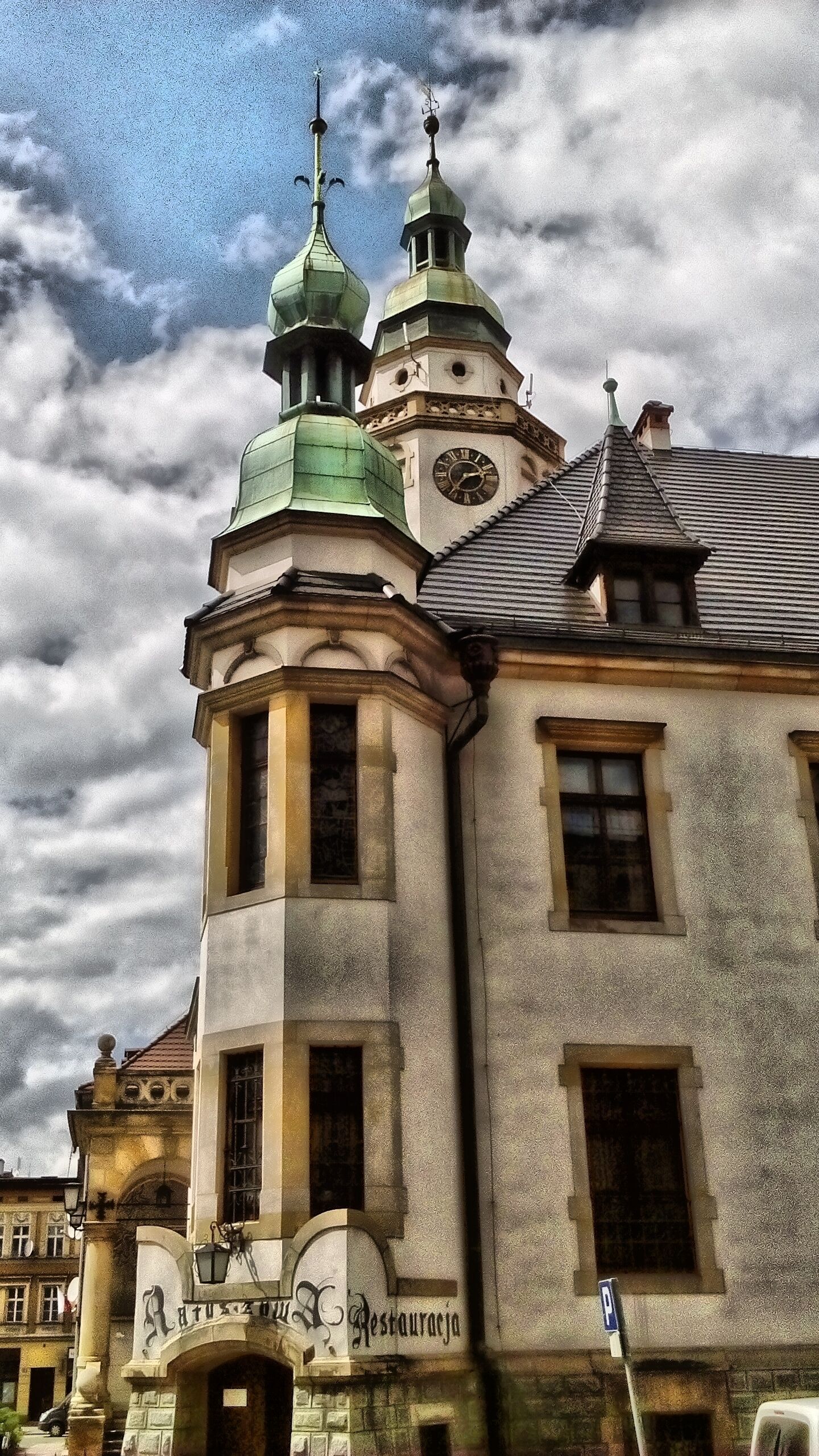 Um edifício histórico com uma torre de relógio e uma placa que diz 'Restaurante'.