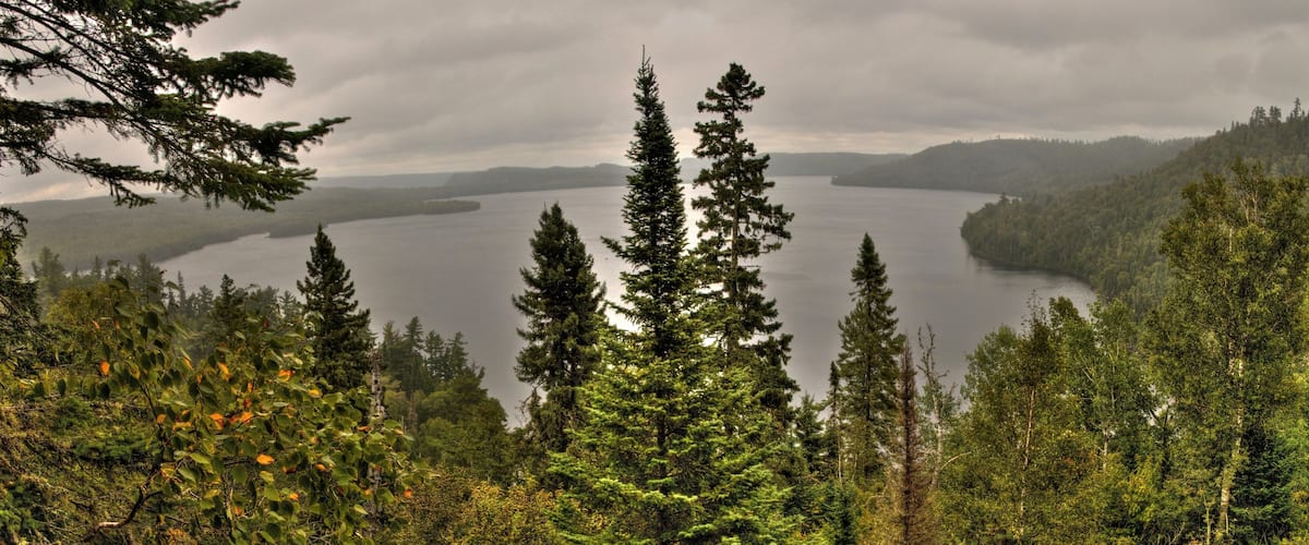 A lake surrounded by dense forest and mountains.