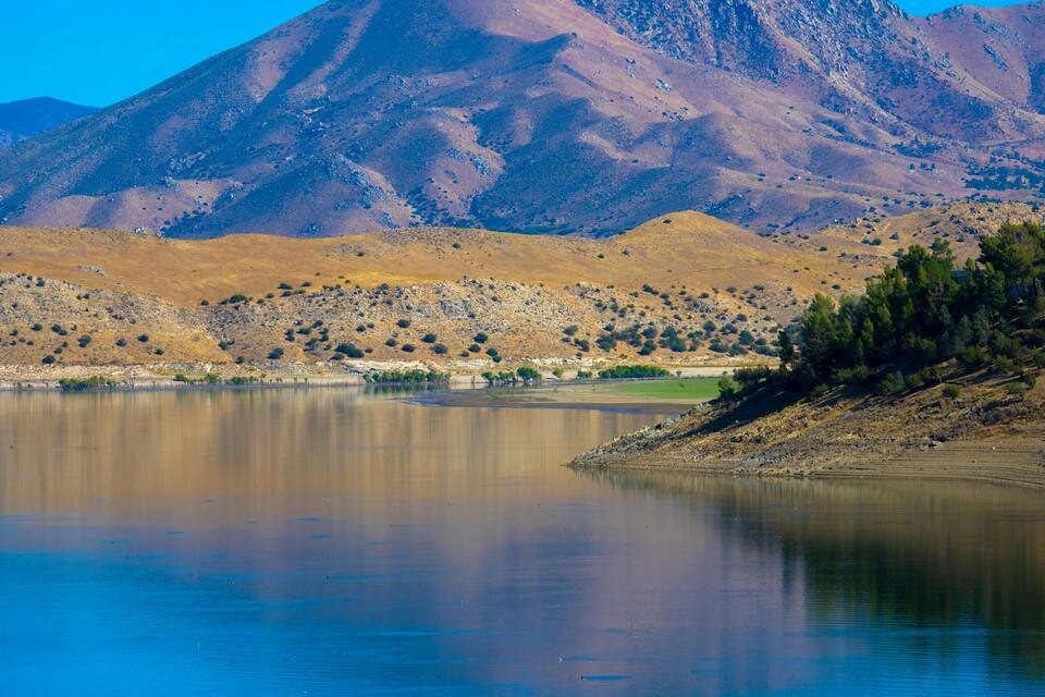 A calm lake with a mountain in the background.