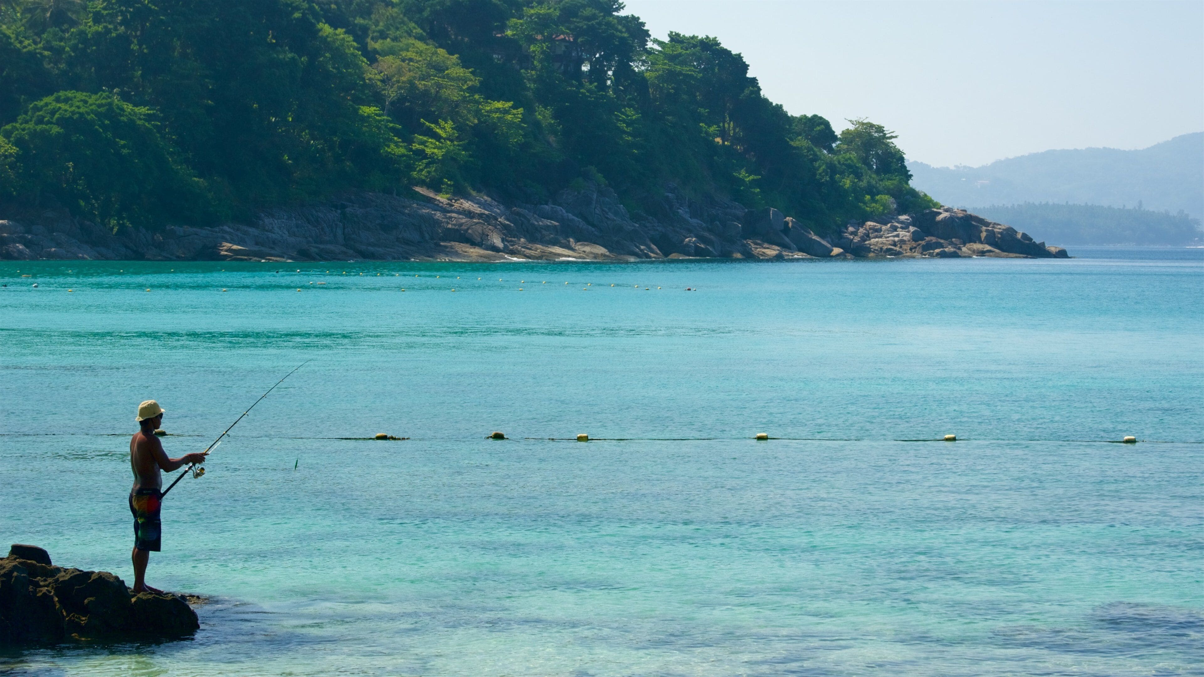 Phuket som inkluderer klippelandskap, fisking og bukt eller havn