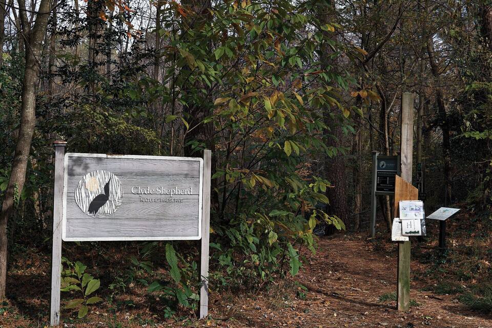 A sign for Clyde Shepherd Nature Preserve surrounded by trees.
