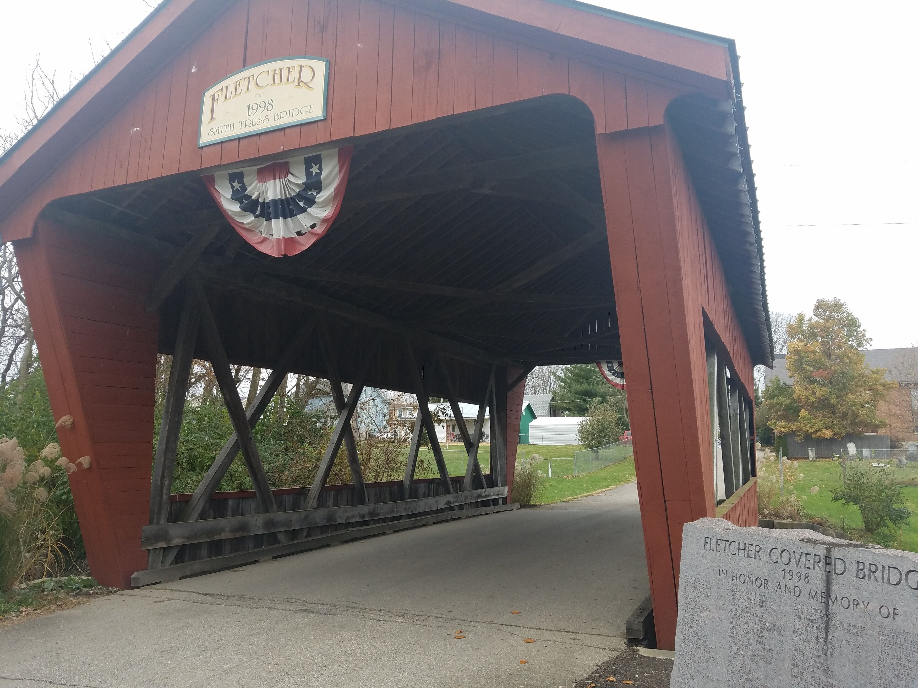 A covered bridge with a sign that reads "Fletcher 1998 Smith Truss Bridge".