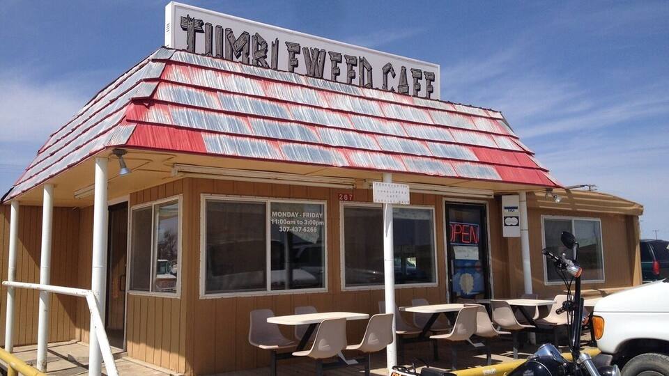 A small roadside cafe with a red roof and wooden exterior.