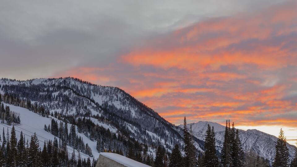 Spectacular sunset view of golden clouds over mountains in winter from Snowbird in Little Cottonwood Canyon in the Wasatch Range near Salt Lake City, Utah, USA.