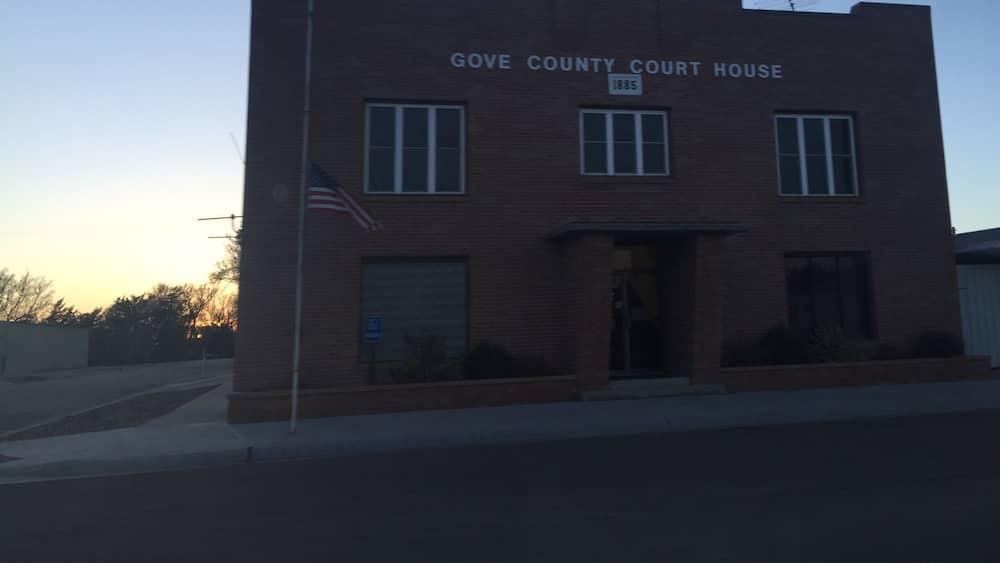 A brick building labeled "Gove County Court House" with an American flag.