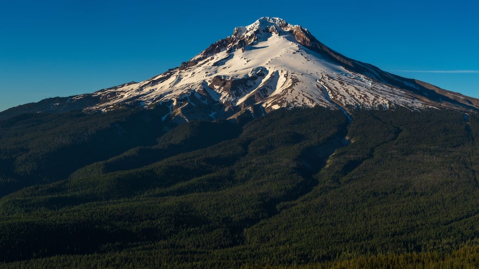 A snow-capped mountain with a clear sky.