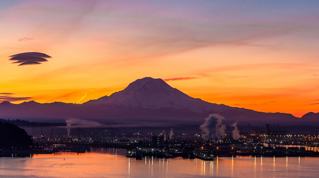 A sunset over a mountainous landscape with a city in the foreground.