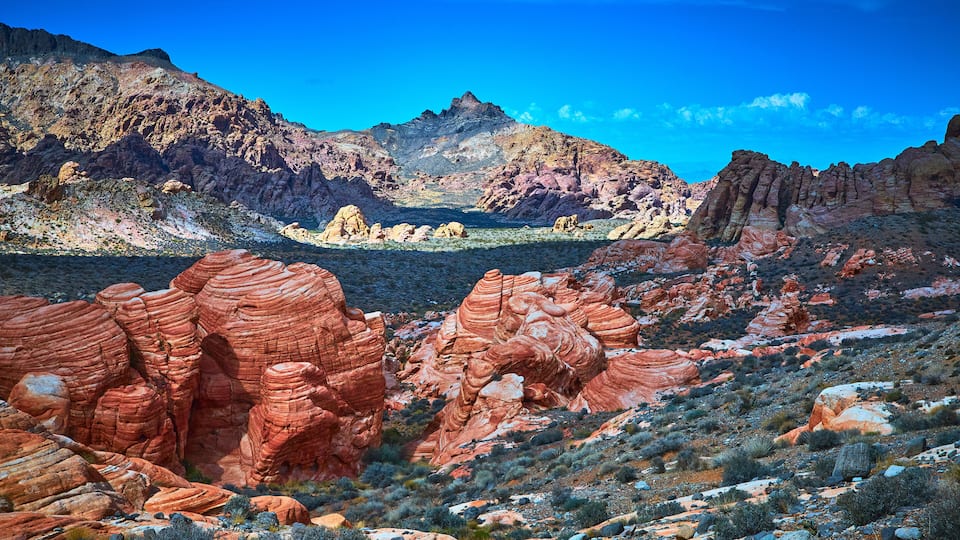 A desert landscape with red rock formations and a clear blue sky.