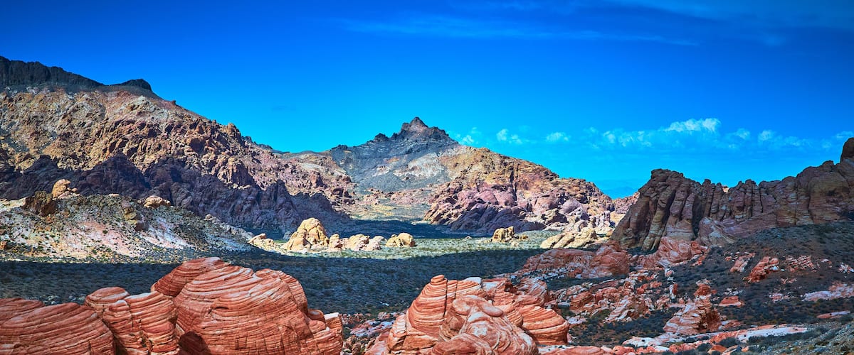 A desert landscape with red rock formations and a clear blue sky.