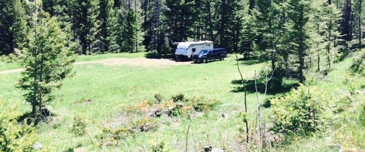 A camping site with a trailer in a forested area.