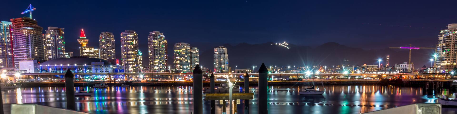 skyline of downtown Vancouver at night with mountains in background
