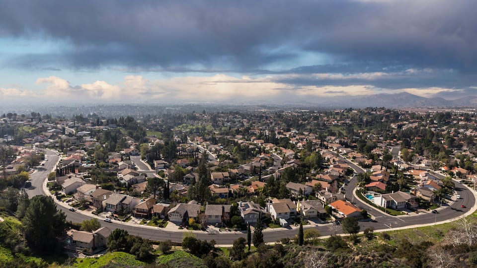 A suburban neighborhood with houses, roads, and a pool.