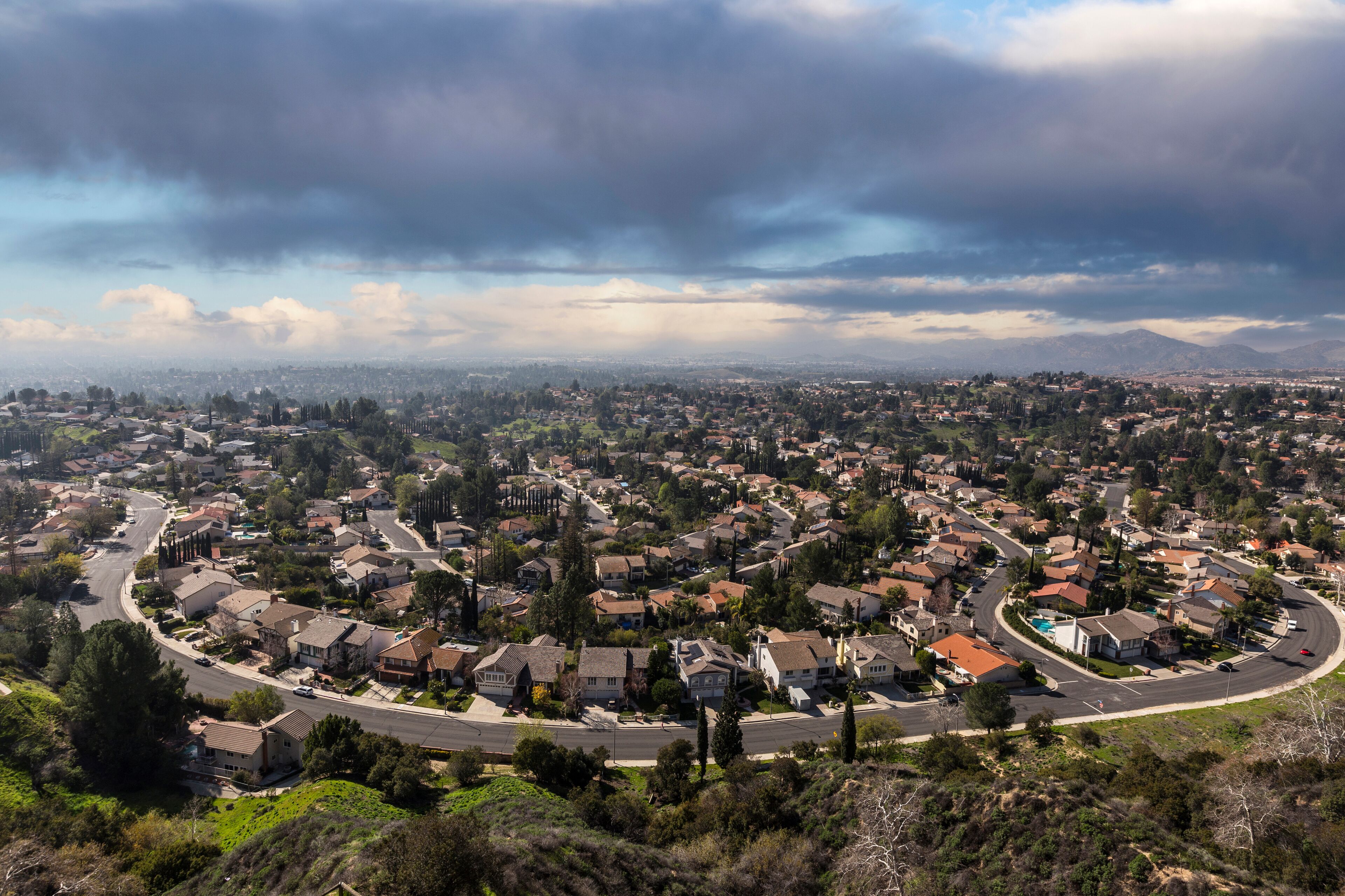 A suburban neighborhood with houses, roads, and a pool.