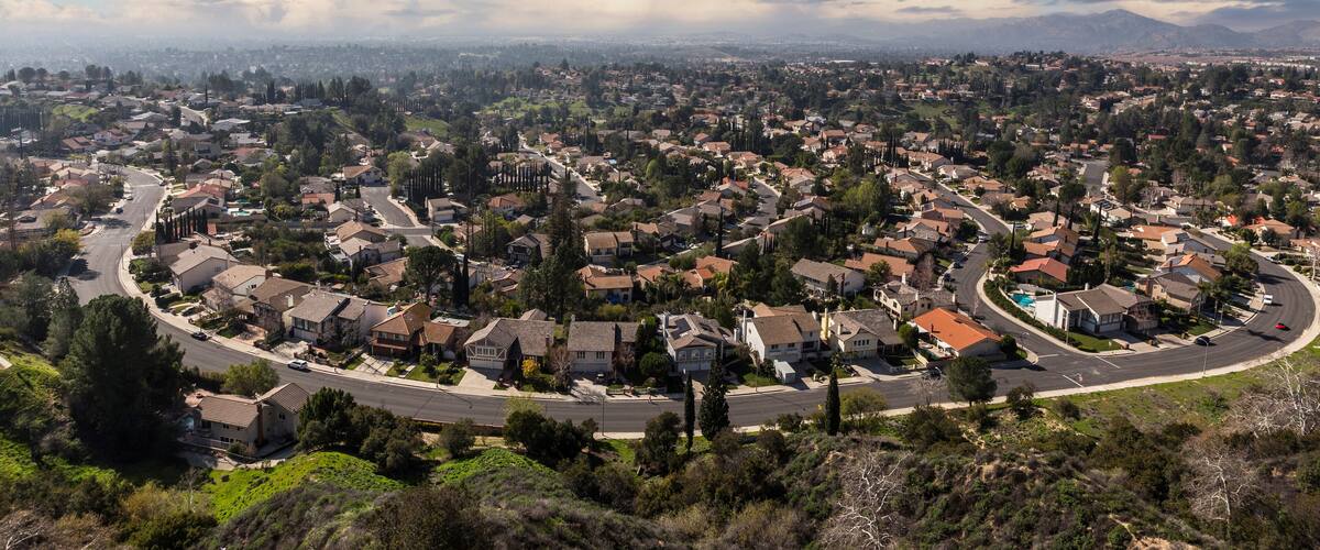 A suburban neighborhood with houses, roads, and a pool.