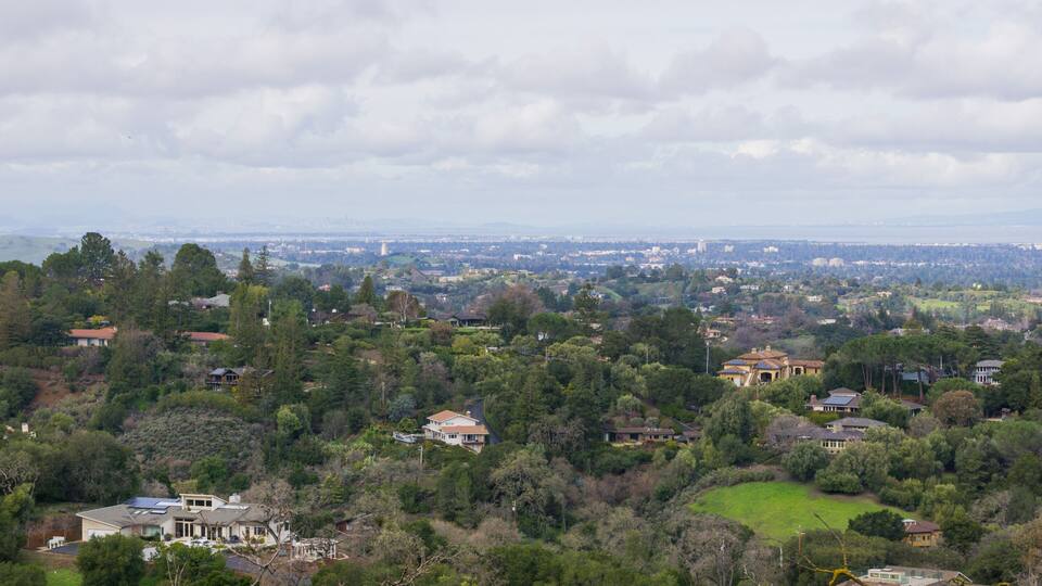 Panoramic view of the Peninsula on a cloudy day; view towards Los Altos, Palo Alto, Menlo Park, Silicon Valley and Dumbarton Bridge and San Francisco in the background, San Francisco bay, California