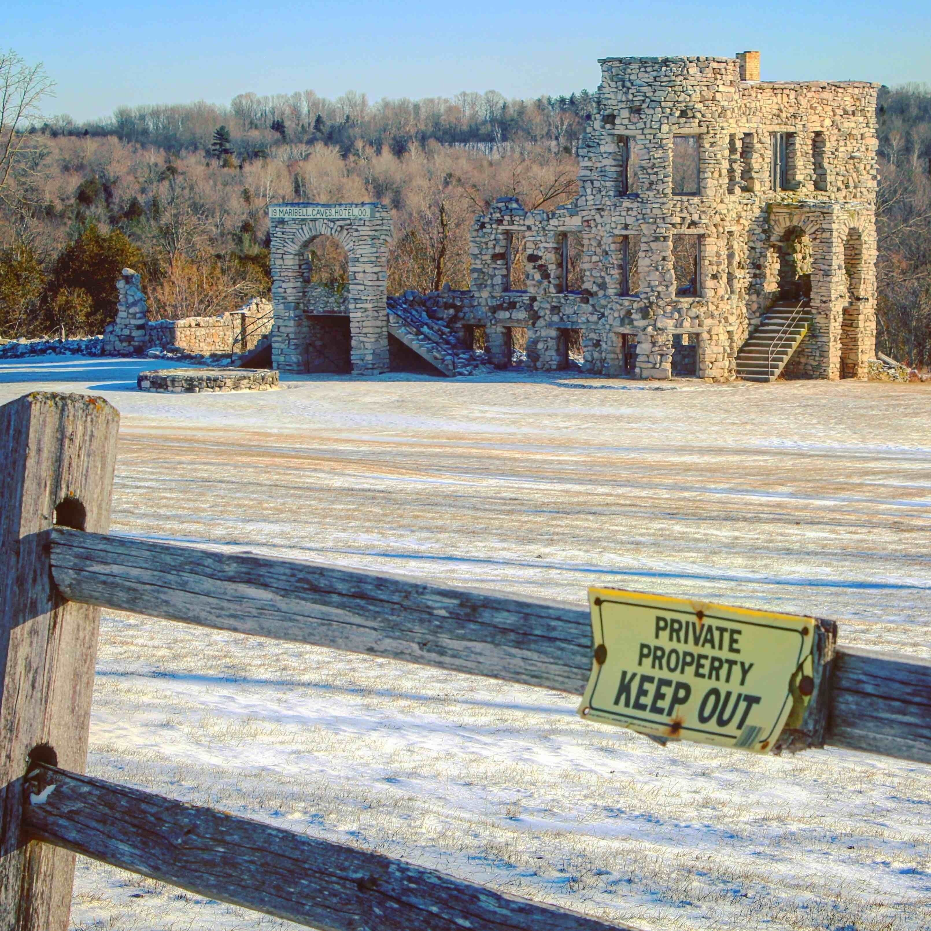 A stone building with a 'PRIVATE PROPERTY KEEP OUT' sign in front.