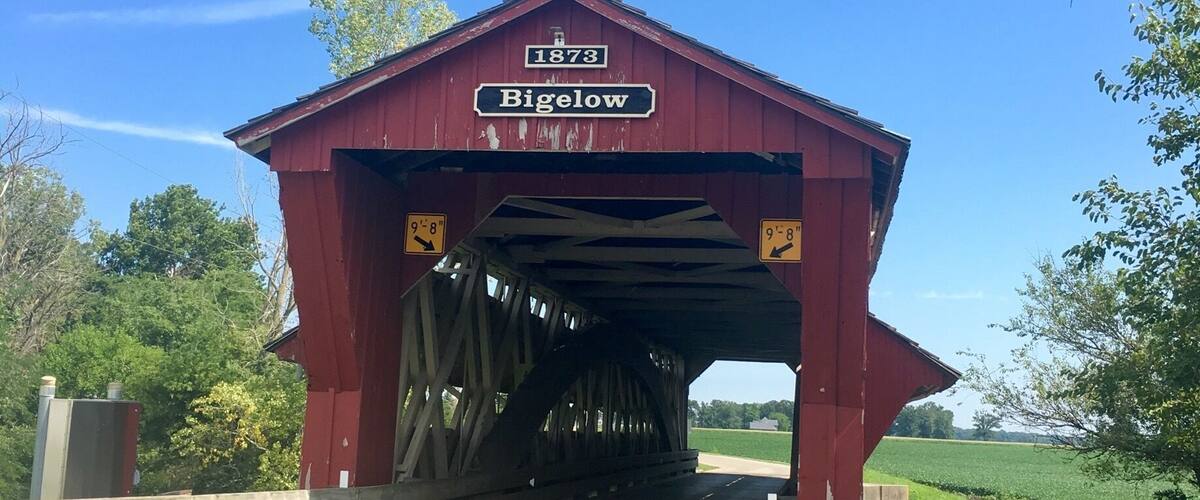 A red covered bridge with '1873 Bigelow' signage.