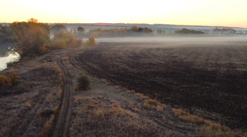 An empty plowed field in autumn at dawn