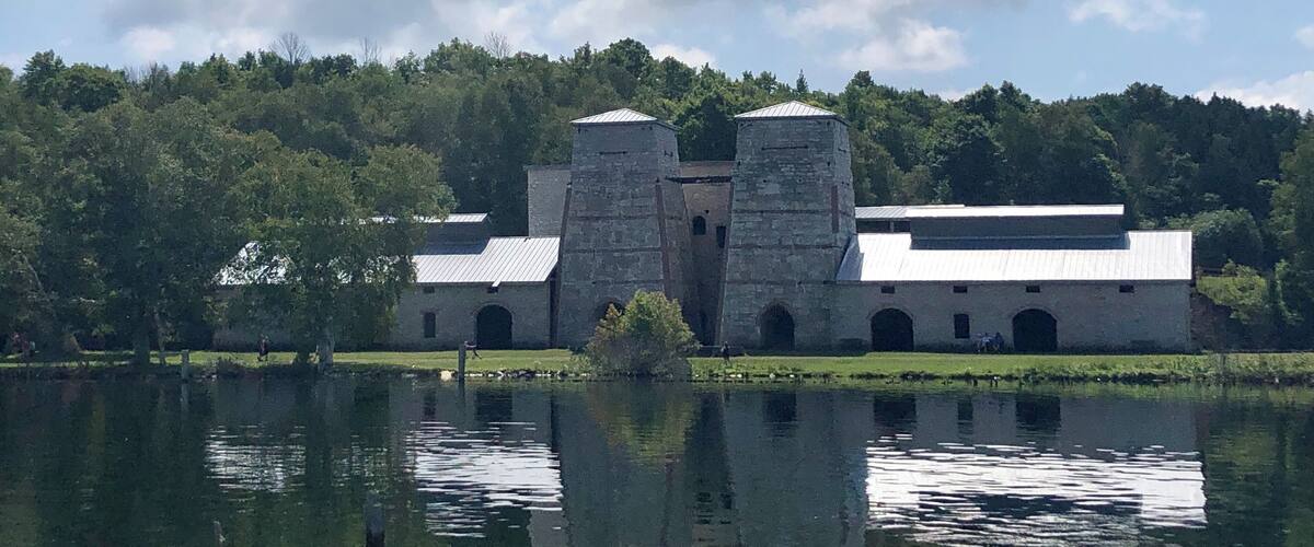 A historic building with two towers by a lake.