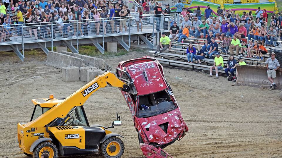 A JCB 505-20 forklift lifting a damaged red car.
