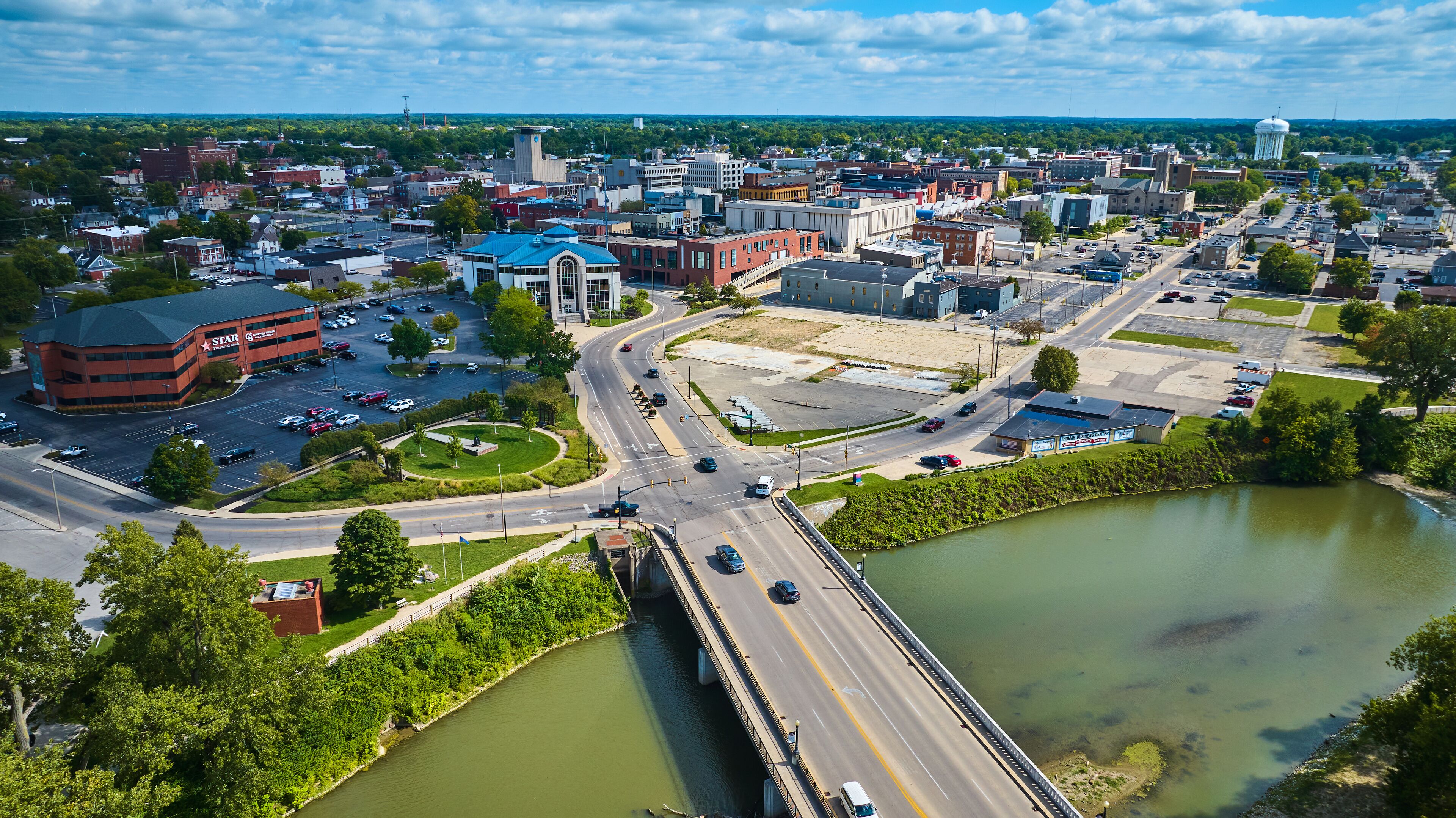 Aerial above White River N High Street bridge overlooking Muncie, IN downtown city buildings