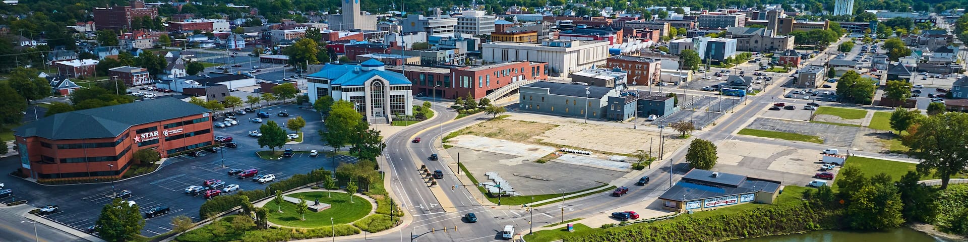 Aerial above White River N High Street bridge overlooking Muncie, IN downtown city buildings