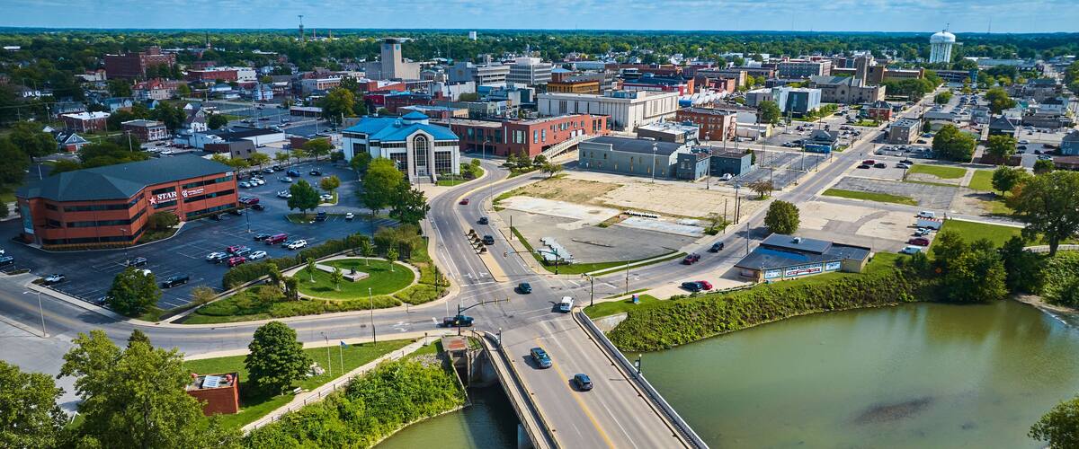 A cityscape with a river, a bridge, and a Starbucks building.
