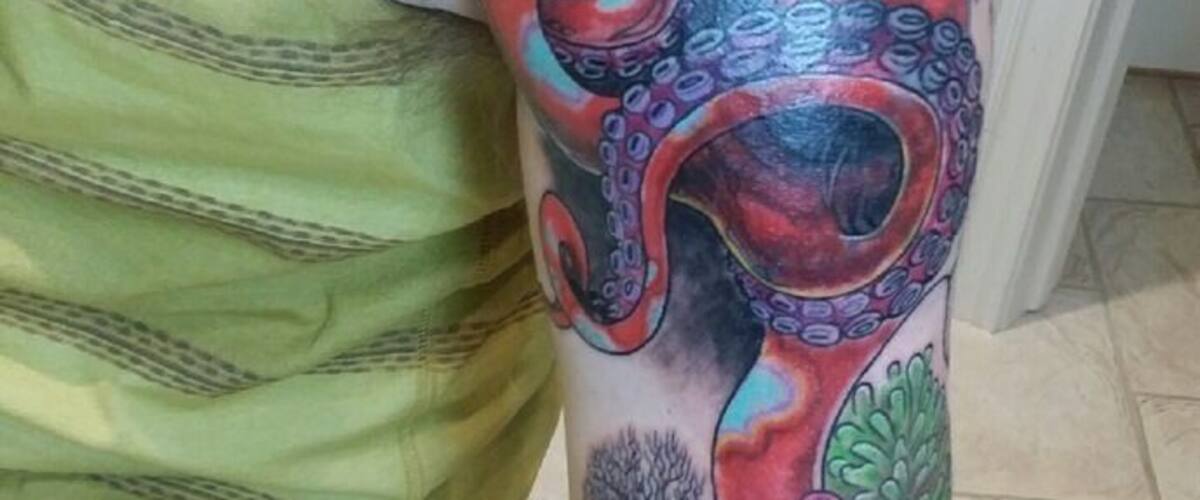 A person with a tattoo of an octopus on their upper arm.