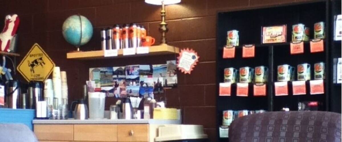 A room with two armchairs, a globe, shelves with canned goods, and a traffic sign.