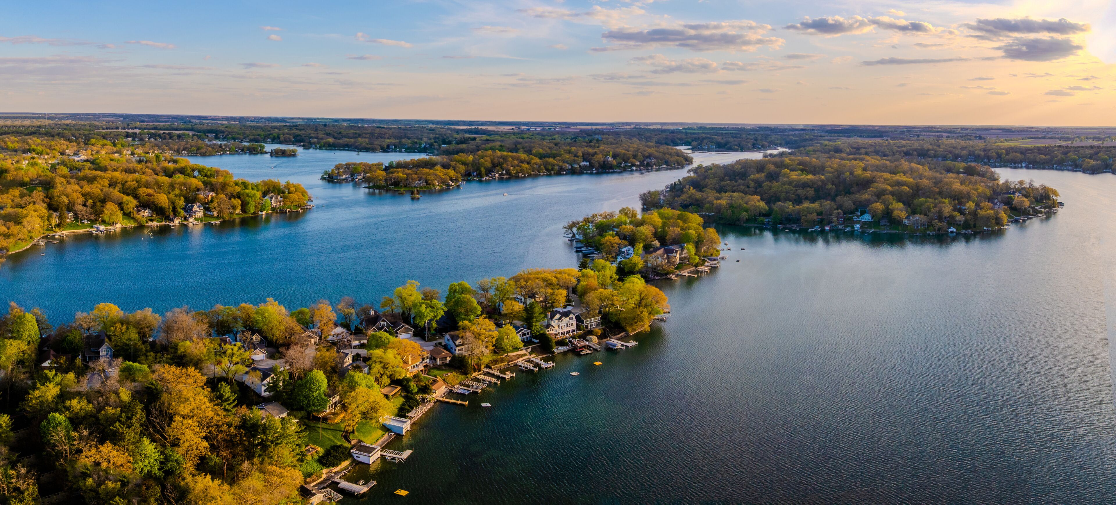 A river with islands, surrounded by dense forests and residential areas.