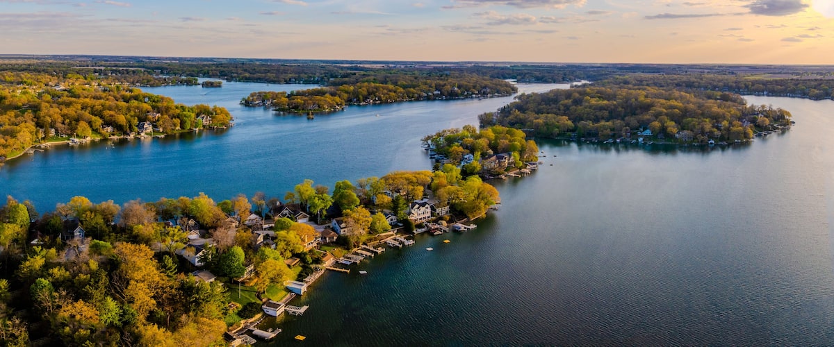 A river with islands, surrounded by dense forests and residential areas.