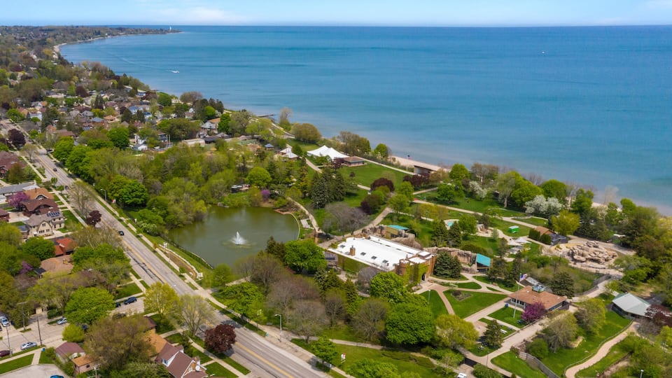 An aerial view of a coastal town with a lake, park, and historic buildings.