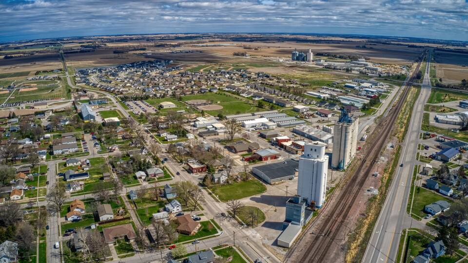 An aerial view of a town with residential areas, industrial buildings, and a railway track.