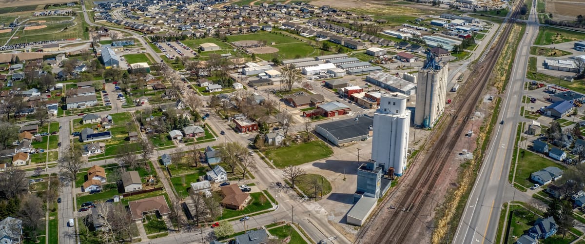 An aerial view of a town with residential areas, industrial buildings, and a railway track.