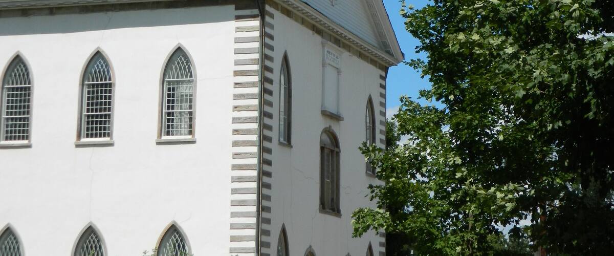 A white church with a steeple and a clock tower.