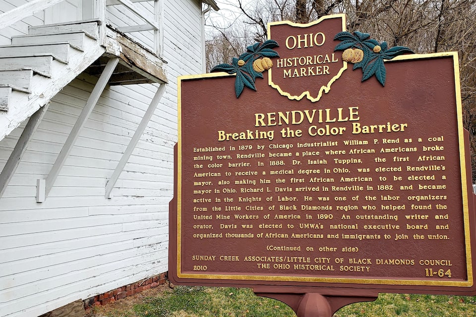 A historical marker sign with text about Reddville's role in breaking the color barrier.