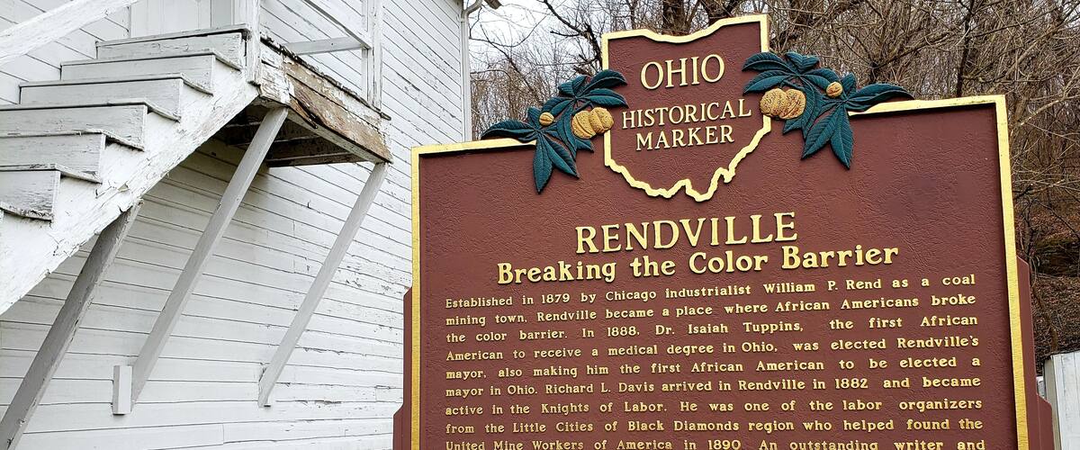 A historical marker sign with text about Reddville's role in breaking the color barrier.
