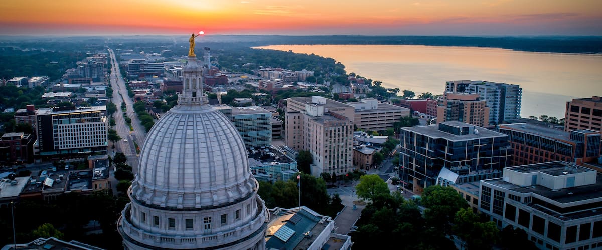 A cityscape with a prominent dome building, a river, and a sunset.