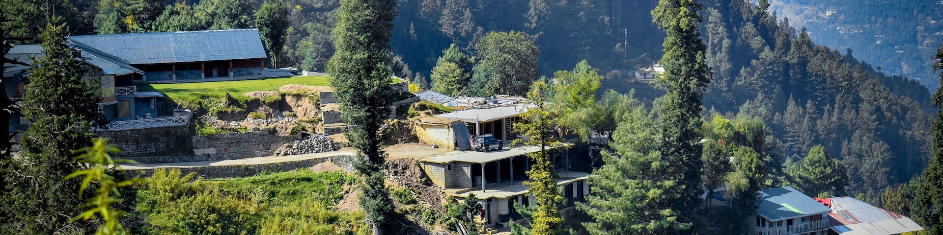 A mountainous landscape with several buildings nestled among trees.