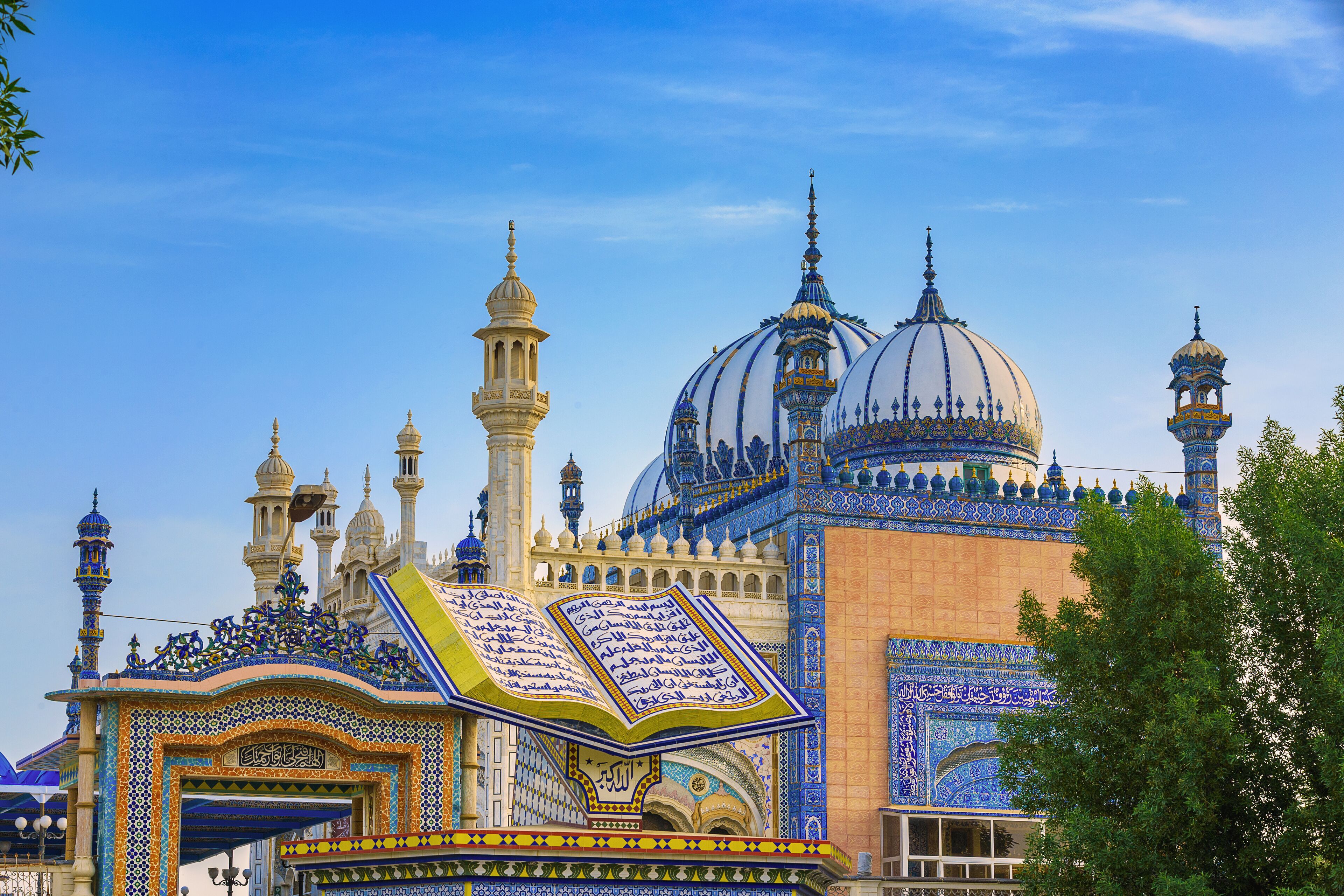 A mosque with intricate blue and gold tile work, domes, and minarets.