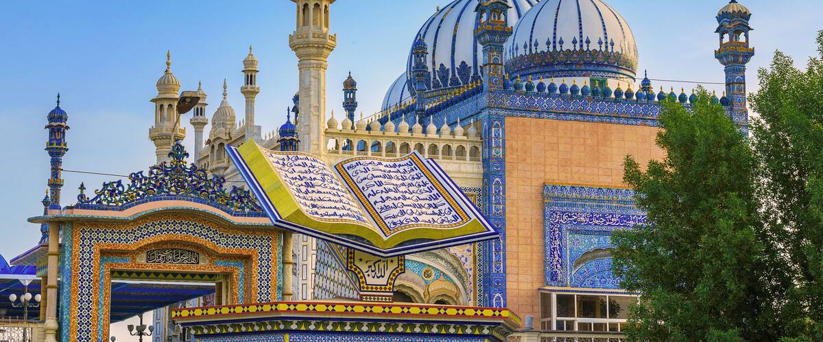 A mosque with intricate blue and gold tile work, domes, and minarets.