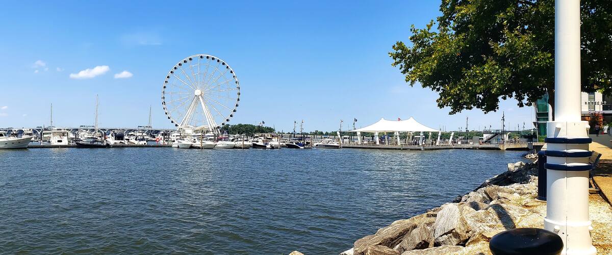View to Ferris wheel and yacht marina pier on the Potomac River in National Harbor, Maryland.