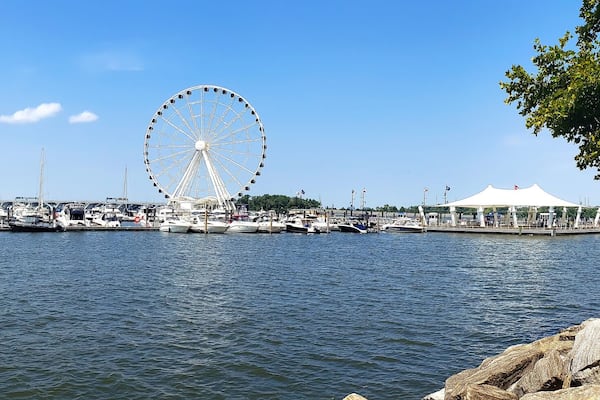 View to Ferris wheel and yacht marina pier on the Potomac River in National Harbor, Maryland.
