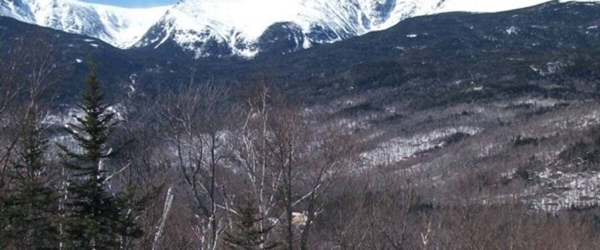 A snowy mountain landscape with skiers.