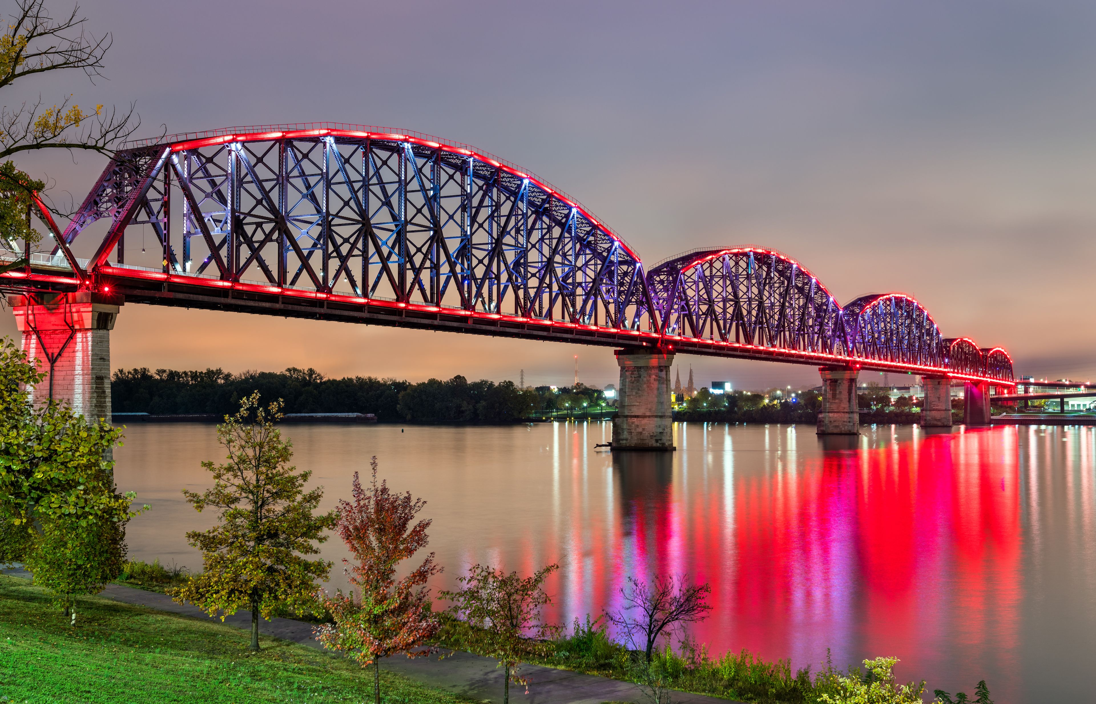 Un puente muy iluminado con varios arcos sobre un río tranquilo.