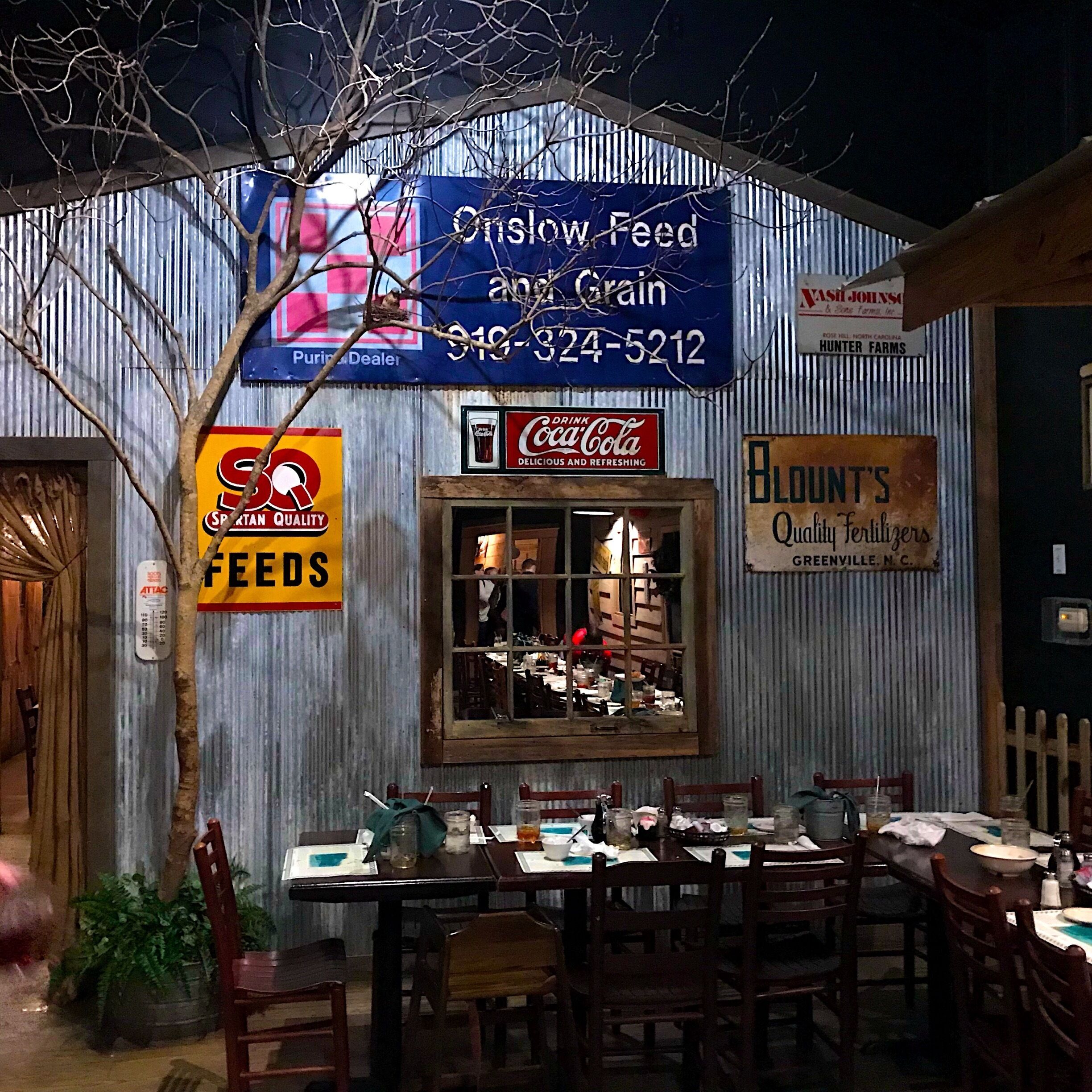 A rustic building with signs for 'Olslow Feed & Grain' and 'Hunter Farms'.