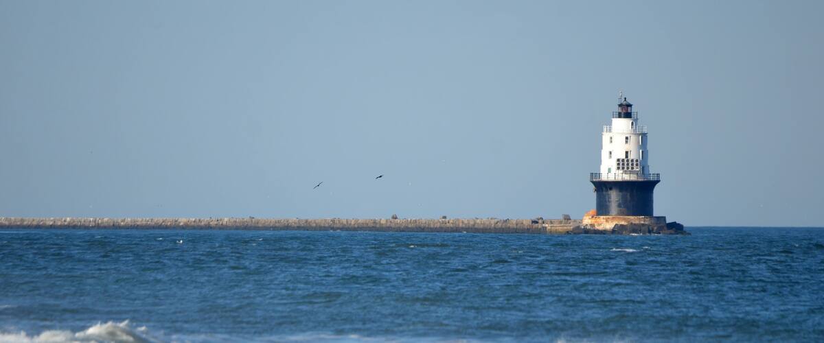 Harbor of Refuge Lighthouse in Cape Henlopen State Park with waves in foreground