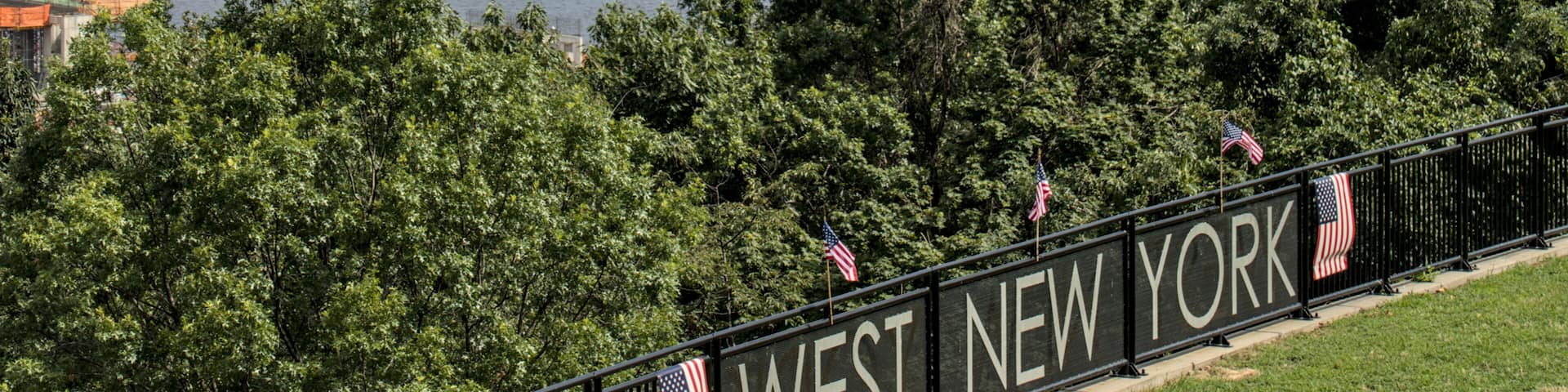 view of midtown manhattan skyline from a public park in west new york (city in jersey, nj, nyc) green space urban living hudson river blue sky clouds skyscraper cityscape high rise