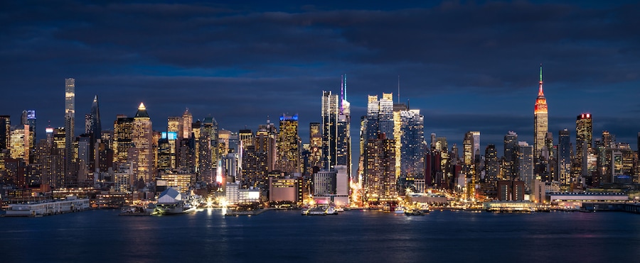 New York City panoramic view at dusk from the Hudson River. The view includes the skyscrapers of Manhattan Midtown West Manhattan illuminated at night. NYC, NY, USA