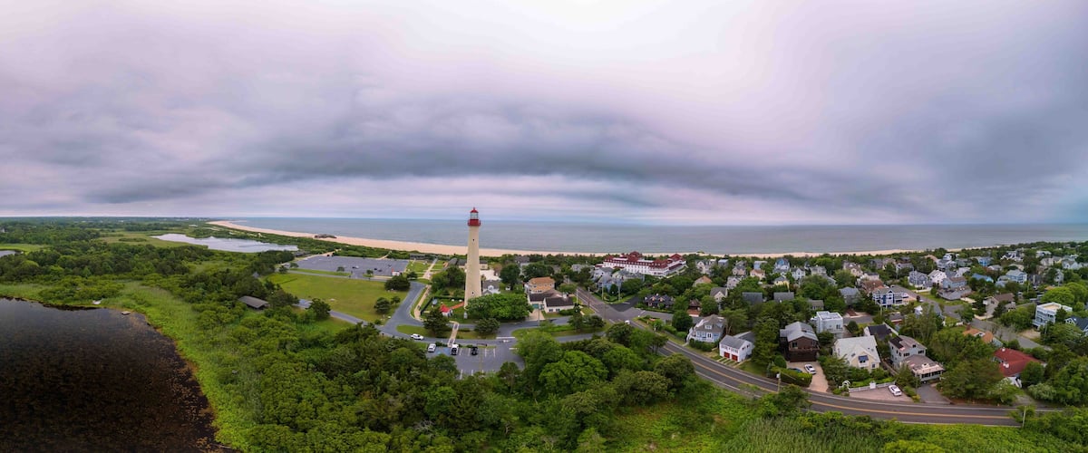 A coastal town with a prominent lighthouse, a river, and a residential area.